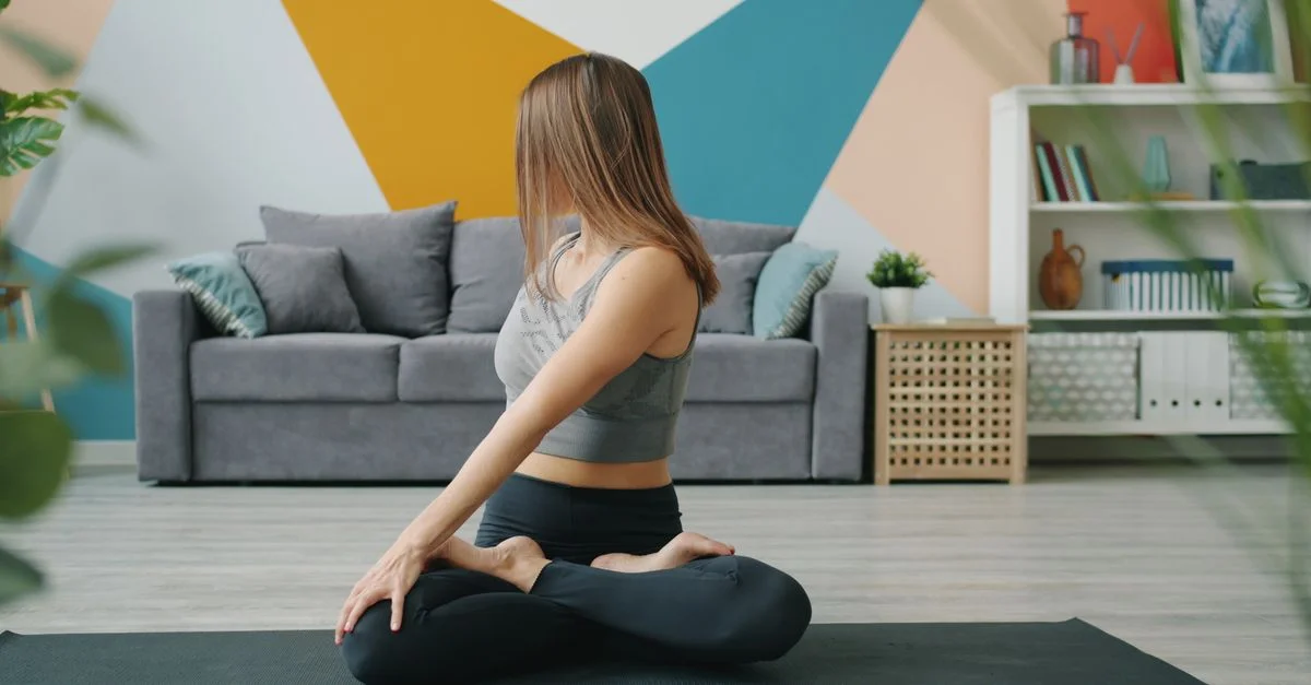 Une femme faisant du yoga dans une pièce moderne sur un tapis.