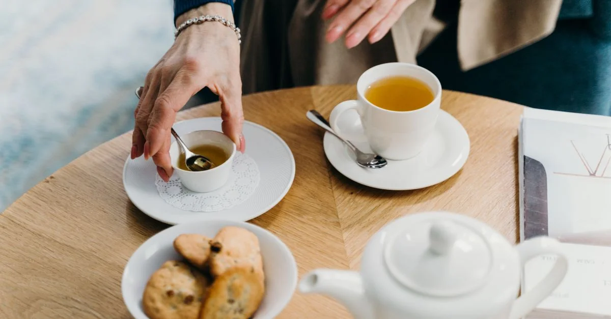 Un cadre de thé matinal serein avec des biscuits et du thé sur une table en bois. Parfait pour refléter la détente.